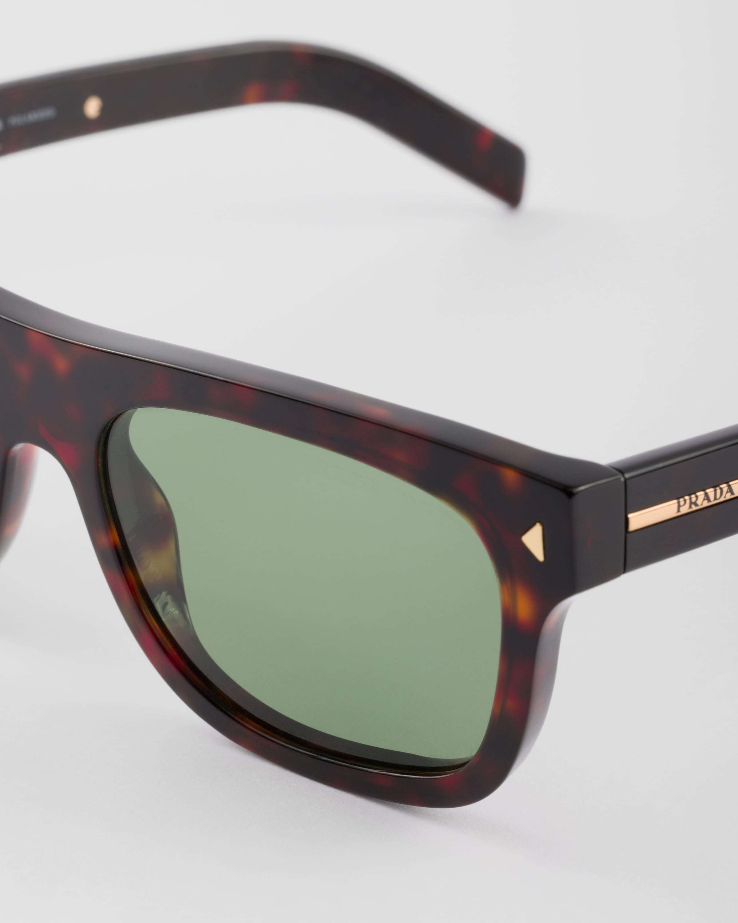 PRADA SUNGLASSES WITH THE ICONIC METAL PLAQUE 
