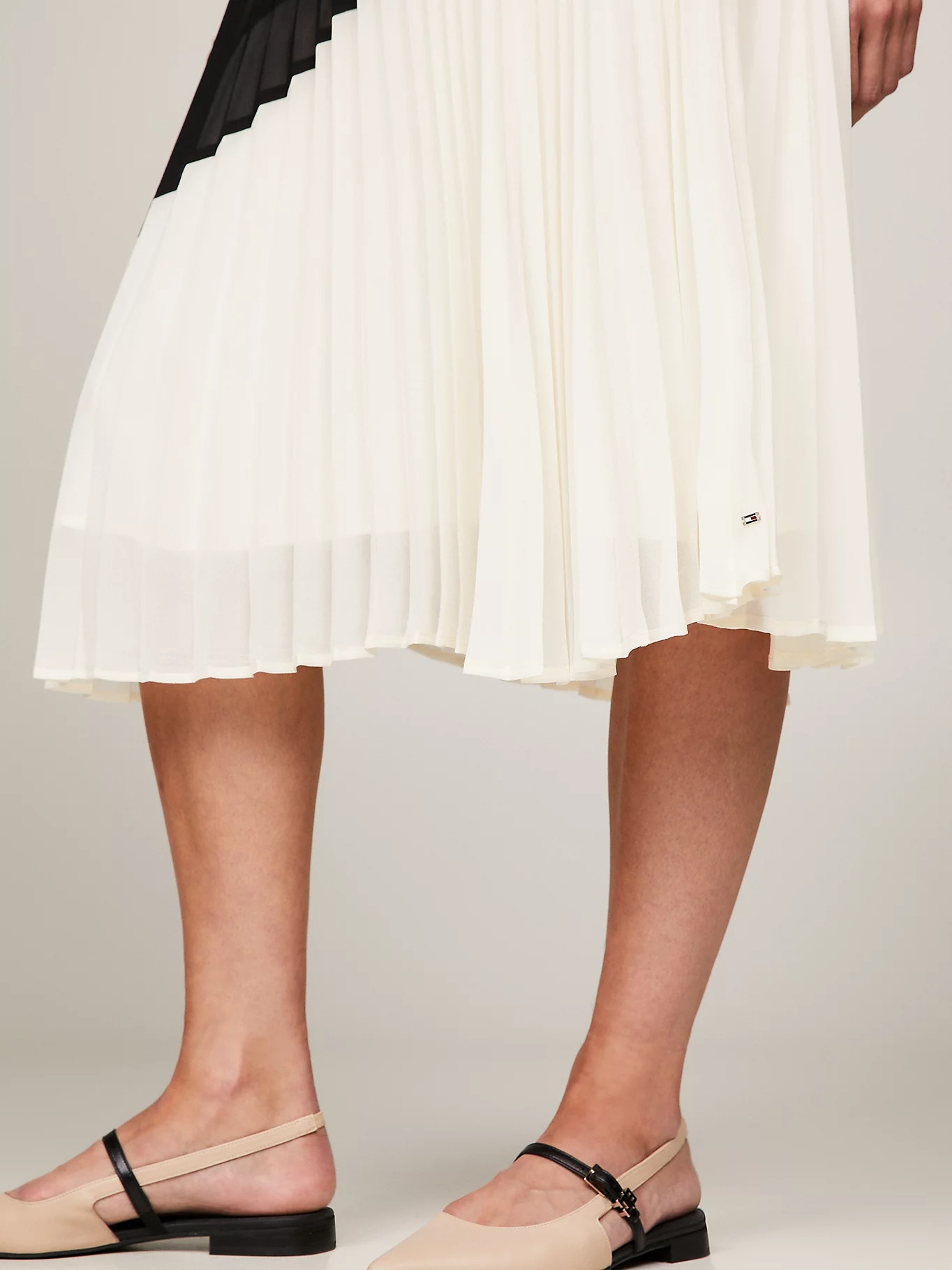 TOMMY HILFIGER A HALF-LENGTH SKIRT WITH PLEATED HORNS.