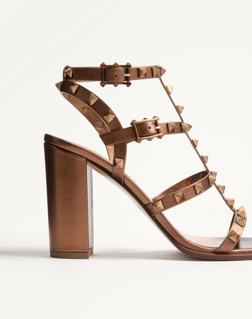 Shop Valentino Rockstud Metallic Calfskin Leather Ankle Strap Sandal 90 Mm In Bronze